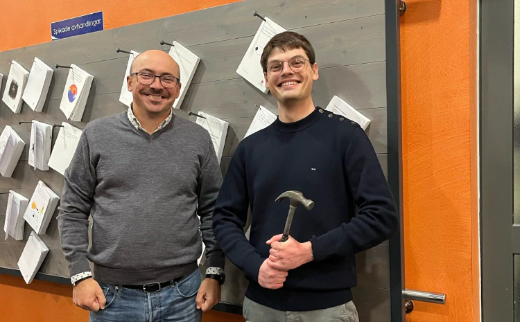 Yuri Khotyaintsev and Louis Richard smiling in front of the thesis nailing board. Photo: Michiko Morooka/IRF