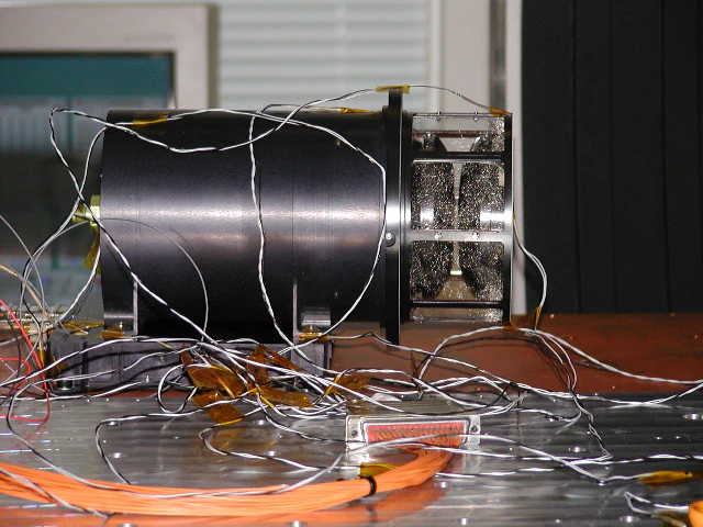 Left: Charged particles from the sun (the solar wind) form an induced magnetosphere round Mars, which unlike the sun does not have its own intrinsic magnetic field (artwork: Anastasia Grigoryeva) Right: Robin Ramstad points out the position of the Swedish instrument ASPERA-3 on a model of the Mars Express spacecraft (photo: Anastasia Grigoryeva)