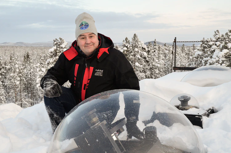 Urban Brändström i vinterkläder på det snötäckta taket till observatoriet